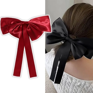 Detail of large satin bow hair clip in red and black with elegant silk texture