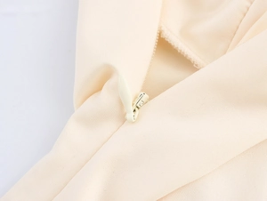 Close-up of the concealed invisible zipper on a beige French style elegant dress