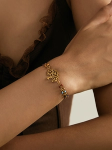 Detailed shot of golden Tree of Life bracelet with colorful beads on female wrist