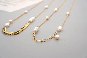 Detail of vintage gold curb chain necklaces with asymmetric freshwater pearls for women