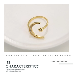 Close-up of golden crescent moon and star open ring with micro-set zircon details