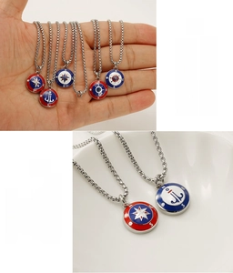 Detail of nautical stainless steel anchor and compass pendants with lead-free enamel