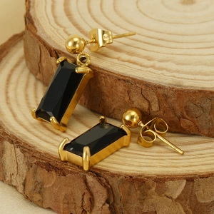 18K gold plated earrings with rectangular black gemstone pendant on a wooden background