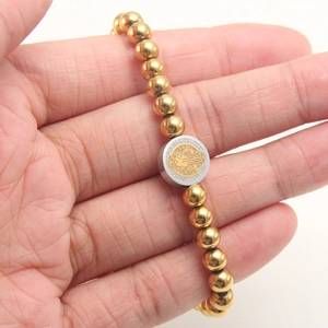 18K gold-plated beaded bracelet featuring a Saint Benedict medal in hand display