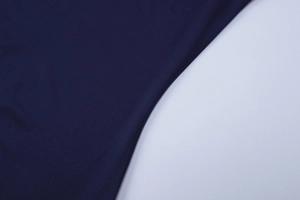 Vue détaillée de la texture du tissu en maille bleu foncé et tissage fin de la robe