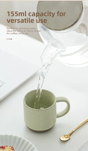Detail of pouring water from a glass pitcher into a 155ml Morandi ceramic coffee mug