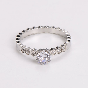 Macro detail of silver honeycomb ring featuring geometric hexagon patterns and clear diamonds