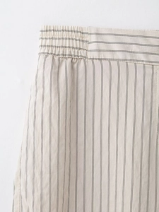 Detail of high-elastic waistband on striped beige pants with premium fabric texture