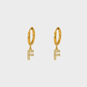 Detailed close-up of golden stainless steel earring with F-letter charm and white zircons