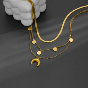 Detail of triple-layer gold necklace featuring flat snake chain and horn crescent pendant