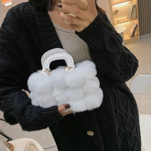 Detail shot of white faux fur handbag texture and fluffy shoulder strap for women