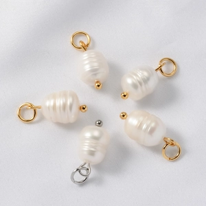 Baroque natural freshwater pearl pendants with gold and silver loops on white fabric