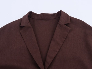 Close-up of maroon British style blazer showing notched lapel and linen fabric texture