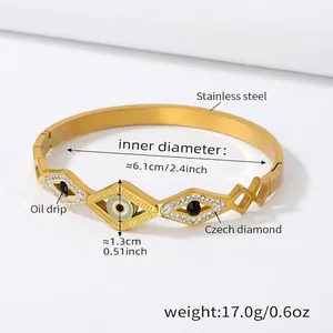 Detailed view of golden stainless steel Evil Eye bangle with blue oil drip and Czech diamonds