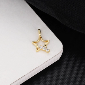 Detailed close-up of 18K gold plated star pendant with three inlaid zircon stones