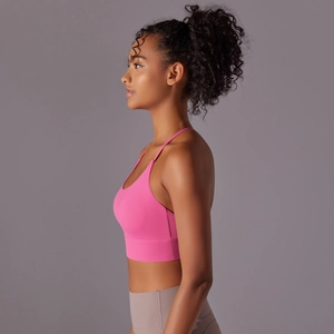 Detail of pink sports bra with cross back straps and wide elastic hem for yoga