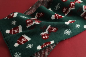 Close-up of knit Christmas scarf featuring festive Santa hat and snowflake patterns