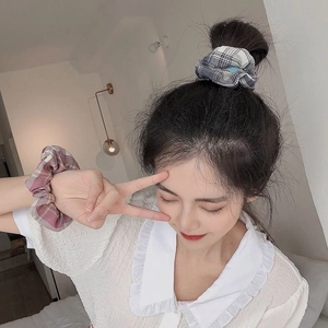 Detail showing blue plaid and pink purple floral scrunchies on hair and wrist
