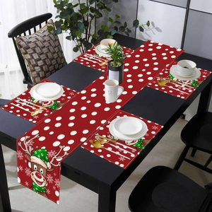 Detail of red Christmas table runner and placemats with elk pattern on a dining table