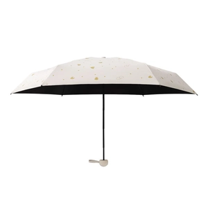Mini cream sun umbrella with gold heart patterns and black UV protection coating