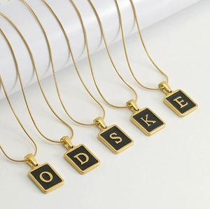 Détail de pendentifs en acier inoxydable doré 18 carats avec lettres en émail noir