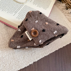 Close-up of handmade fabric coin purse with polka dot embroidery and a vintage button