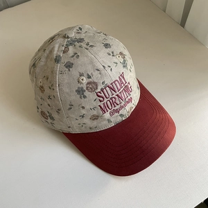 Détail de la casquette fleurie avec broderie Sunday Morning et visière rouge courbée