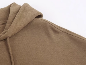 Detailed close-up of khaki knit hoodie showing shoulder seams and ribbed texture