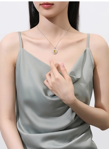 Close-up of S925 silver necklace with flower pendant featuring a yellow gemstone center