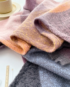 Close-up of soft plaid scarf texture with colorful fringe and woven material details