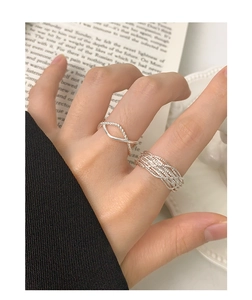 Close-up of a twisted silver ring with intricate woven texture on a hand