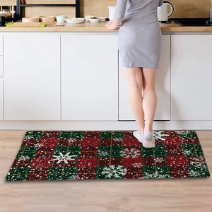 Macro shot of festive red and green plaid Christmas kitchen mat with snowflake pattern