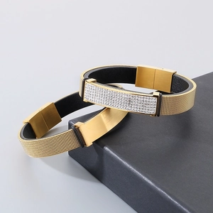 Gold mesh and black leather bracelet set with sparkling zircon stones on a jewelry box