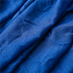 Macro shot of dark blue cotton linen fabric with sparkling sequins and woven texture