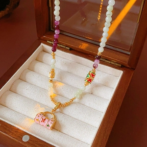 Macro detail of enamel flower basket pendant with zircon on beaded vintage style necklace