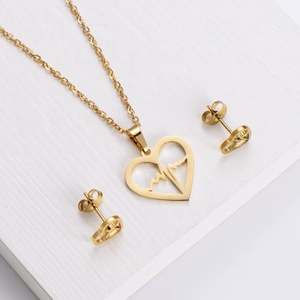 Parure de bijoux dorés cœur et électrocardiogramme sur fond de bois blanc élégant