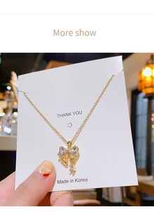 Gros plan sur le collier pendentif nœud doré avec cristaux de zircon sur carte