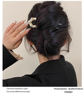 Detail of elegant gold U-shaped hair pin with pearls on a low bun hairstyle