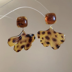 Détail des boucles d'oreilles feuille de ginkgo léopard et carré ambre résine
