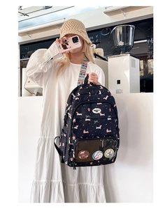 Close-up of black cartoon dog print backpack with transparent PVC pocket and pins