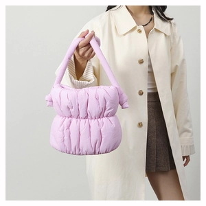 Close-up of pink quilted nylon bucket bag featuring puffy cloud texture and knot handle