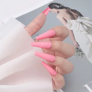 Faux ongles ballerine longs rose mat à presser présentés sur une main avec décor doux
