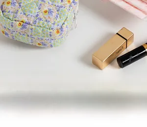 Close-up of a floral quilted cotton makeup bag with a white zipper on a desk