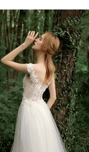 Close-up of white lace bridal gown with delicate pearl beading and floral embroidery