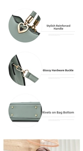 Close-up of green handbag handles with heart hardware and protective bottom studs