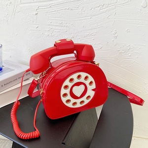 Detailed close-up of creative red patent leather telephone-shaped crossbody bag