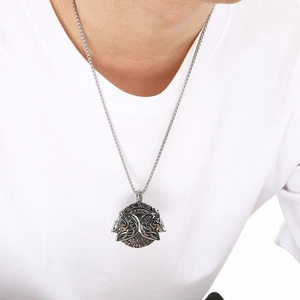 Detailed view of a silver Nordic wolf head pendant necklace on a silver box chain for men