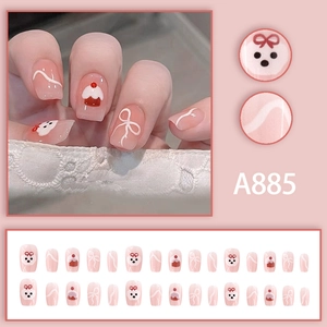 Set di unghie finte rosa con graziosi disegni di cani, cupcake e piccoli fiocchi