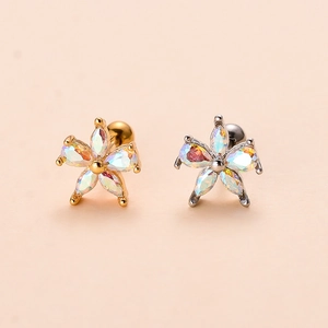 Detail of flower stud earrings in gold and silver finish with iridescent zircon stones