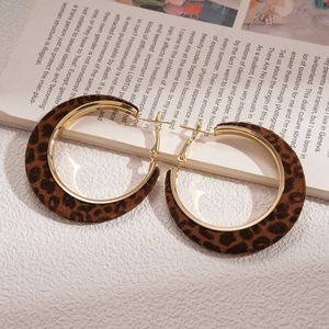 Close-up of vintage gold leopard print flocking hoop earrings on a book background
